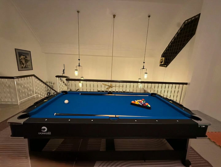Full-size blue pool table in Villa Rinting game area